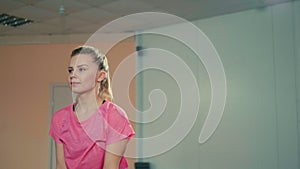 Young Woman is Doing Sport Exercise and Lifting Dumbbells at Fitness Training