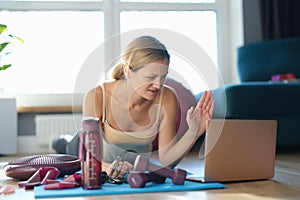 Young woman doing sports exercises with an online trainer