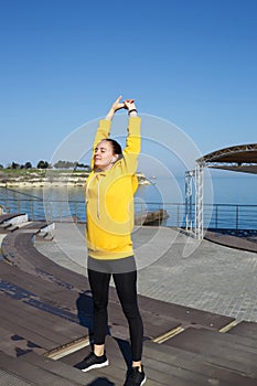 young woman doing sports outdoors by the sea