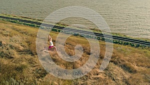 Young woman doing sports outdoors, yoga. aerial video