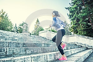 Young woman doing sports and running up the stairs