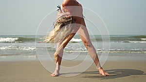 Young woman doing sports workout on the sea beach