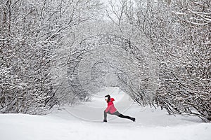 Young woman doing stretching exercises during winter