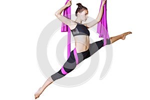 Young woman doing stretching. Fitness, stretch, balance, exercise and healthy lifestyle people. Woman using hammock