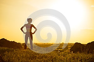 Woman Doing Stretching Outdoor. Warm up Exercise Against Sunset. Sport and Healthy Active Lifesyle Concept. photo