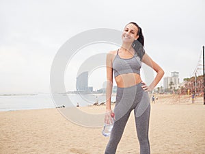 young woman doing stretching at Playa de la Barceloneta - Barcelona Spain.