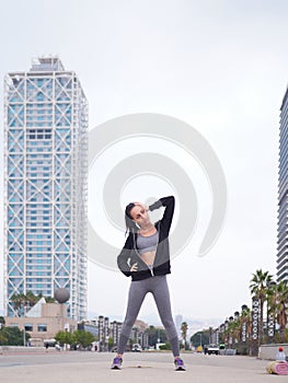 young woman doing stretching at Playa de la Barceloneta - Barcelona Spain.