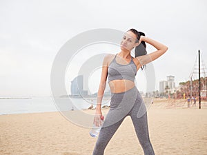 young woman doing stretching at Playa de la Barceloneta - Barcelona Spain. photo