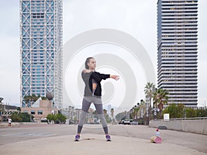 young woman doing stretching at Playa de la Barceloneta - Barcelona Spain. photo