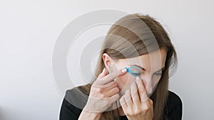 Young woman doing the taping around the eyes to rejuvenate