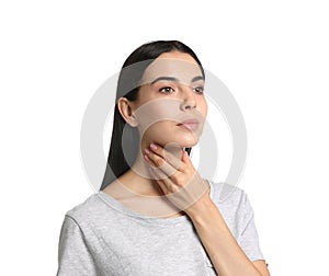 Young woman doing thyroid self examination on white background