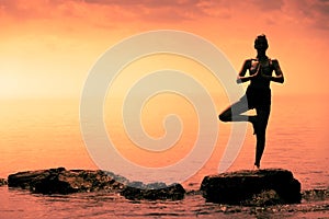 Young Woman doing the Tree Yoga Position During Sunset