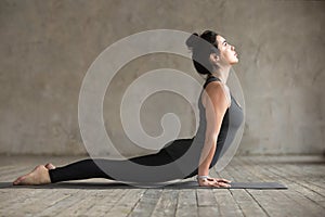 Young woman doing upward facing dog exercise