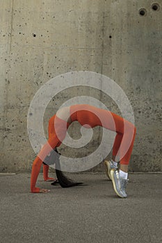 Young woman doing the wheel. Urdva dhanurasana yoga pose. Flexible athlete doing a backbend. Copy space.