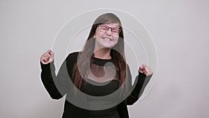 Young woman doing winner gesture with arms raised, laughing, smiling