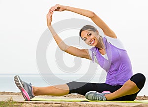 Young woman doing workout on beach on morning