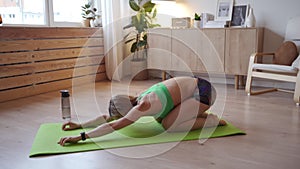 Young woman doing workout at home. Caucasian woman doing bodyweight exercises on yoga mat