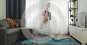 Young woman doing workout at home. Fitness girl doing yoga exercises on mat. Healthy and sport lifestyle.