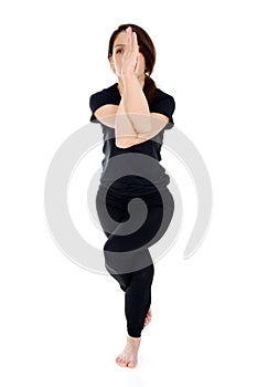 Young woman doing yoga asana Garudasana Eagle Pose