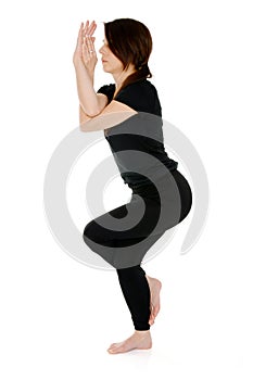Young woman doing yoga asana Garudasana Eagle Pose