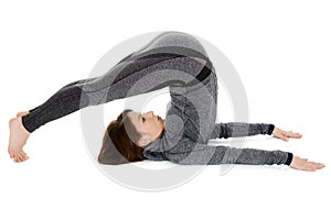 Young woman doing yoga asana Halasana or Plow Pose