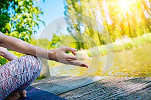 young woman doing yoga asana in park. girl stretching exercise in yoga position. happy and healthy woman sitting in