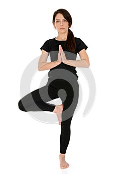 Young woman doing yoga asana Tree Pose Vrksasana