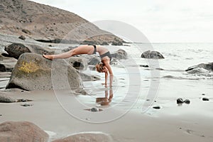 Young woman doing yoga at the beach