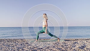 Young woman is doing yoga on the beach