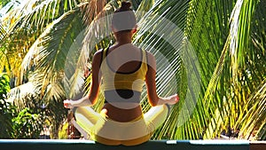 Young woman doing yoga breathing pose outside in natural environment