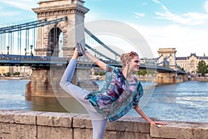 Young woman doing yoga at Danube in city, Budapest, Hungary