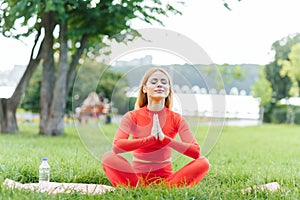 Young woman doing yoga exercise in green park