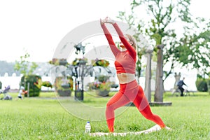 Young woman doing yoga exercise in green park