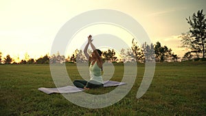 Young woman doing yoga exercise in green park