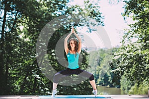 Young woman doing yoga exercise in park.