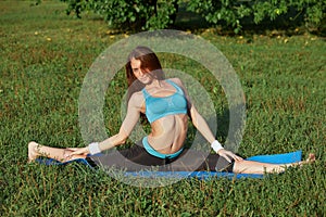 Young woman doing yoga exercise on park