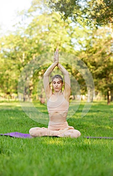 Young woman doing yoga exercise and relax in morning park at summer