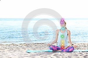 Young woman doing yoga exercises on beach