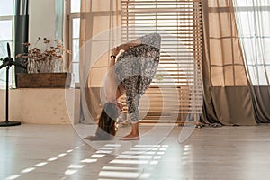 Young woman doing yoga exercises early in the morning. Meditates after sleep in a bright sunny room. Healthy lifestyle .sport