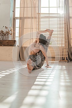 Young woman doing yoga exercises early in the morning. Meditates after sleep in a bright sunny room. Healthy lifestyle .sport