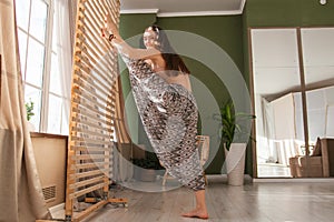 Young woman doing yoga exercises early in the morning. Meditates after sleep in a bright sunny room. Healthy lifestyle .sport