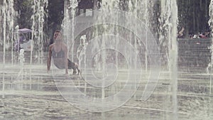 Young woman doing yoga exercises inside the fountain