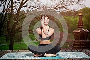 Young woman doing yoga exercises outdoors. Yoga meditation in park