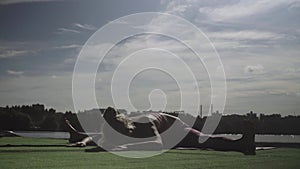 Young woman doing yoga exercises on the river bank