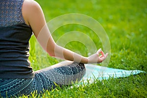 Young woman doing yoga exercises in the summer city park.