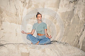 Young woman doing yoga exercises in the white mountains. Relax yoga at the top of the mountain