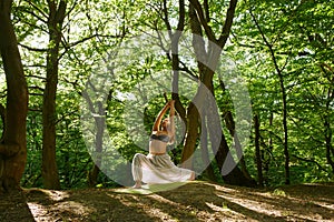 Young woman doing yoga in the forest