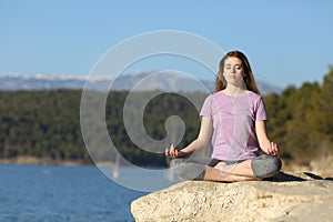 Young woman doing yoga in a lake