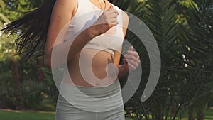 Young woman doing Yoga outdoors in park in white sportswear. Active vacation.