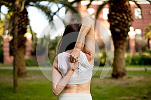 Young woman doing Yoga outdoors in park in white sportswear. Active vacation.